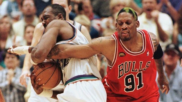 SALT LAKE CITY, UNITED STATES: Dennis Rodman (R) of the Chicago Bulls gets his arm caught by Karl Malone (L) of the Utah Jazz 14 June as Rodman tries for the ball during game six of the NBA Finals at the Delta Center in Salt Lake City, UT. The Bulls won the game 87-86 to win their sixth NBA Championship. AFP PHOTO/Jeff HAYNES