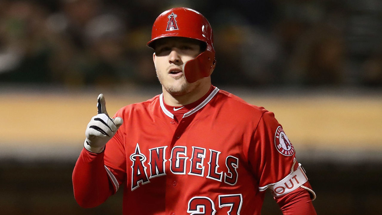 OAKLAND, CA - SEPTEMBER 18: Mike Trout #27 of the Los Angeles Angels reacts as he crosses in front of Jonathan Lucroy #21 of the Oakland Athletics after he hit a home run in the fourth inning at Oakland Alameda Coliseum on September 18, 2018 in Oakland, California.