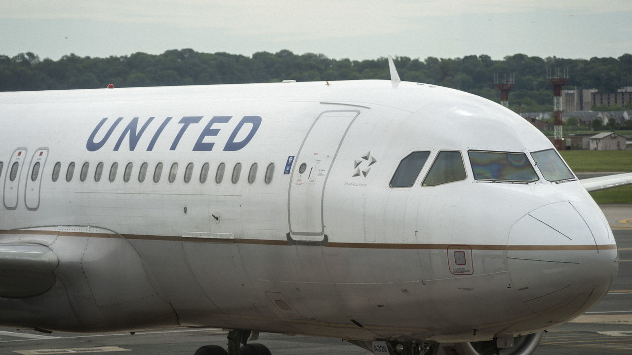 ARLINGTON, VA - MAY 05: A United Airlines plane sits at a gate Ronald Reagan Washington National Airport, May 5, 2020 in Arlington, Virginia. According to leaked internal memos, United Airlines plans to cut at least 3,400 management and administrative positions in October and potentially lay off up to 30 percent of their pilots.