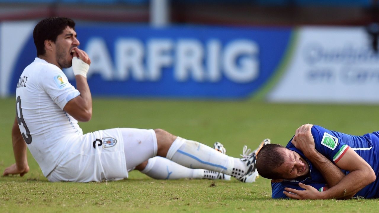 Uruguay's forward Luis Suarez (L) reacts past Italy's defender Giorgio Chiellini during a Group D football match between Italy and Uruguay at the Dunas Arena in Natal during the 2014 FIFA World Cup on June 24, 2014. AFP PHOTO/ JAVIER SORIANO