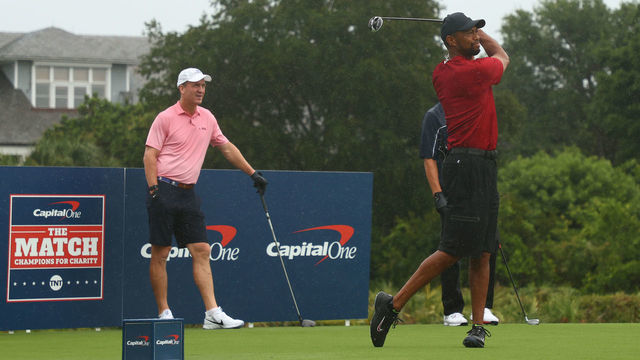 HOBE SOUND, FLORIDA - MAY 24: Tiger Woods plays his shot from the first tee as former NFL player Peyton Manning looks on during The Match: Champions For Charity at Medalist Golf Club on May 24, 2020 in Hobe Sound, Florida.
