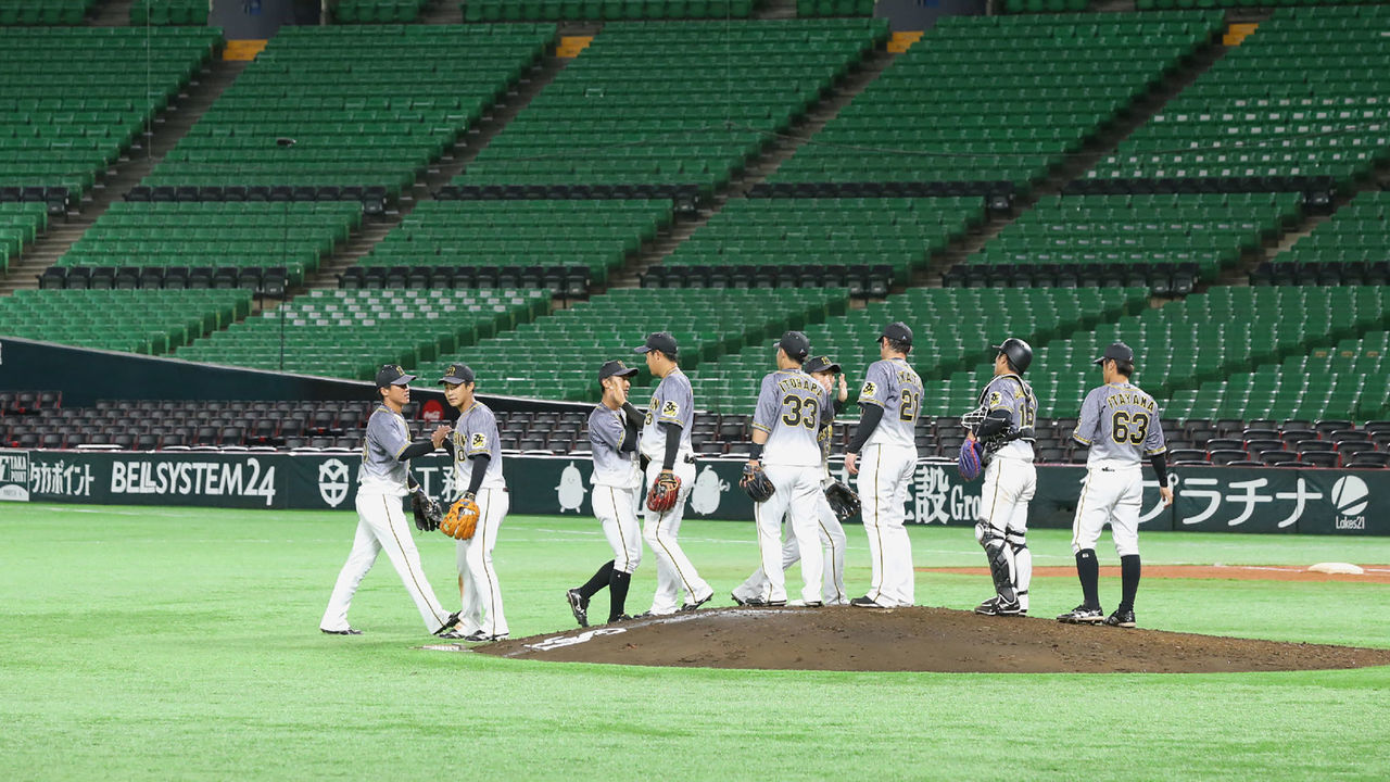 Japan's professional baseball payers of Hanshin Tigers celebrate their win over Fukuoka Softbank Hawks following their pre-season games behind closed doors in Fukuoka on February 29, 2020.