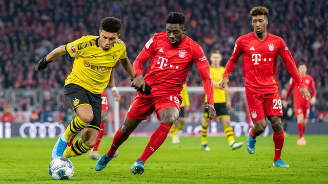 MUNICH, GERMANY - NOVEMBER 09: Jadon Sancho of Borussia Dortmund is challenged by Alphonso Davies of FC Bayern Muenchen and Kingsley Coman of FC Bayern Muenchen during the Bundesliga match between FC Bayern Muenchen and Borussia Dortmund at Allianz Arena on November 09, 2019 in Munich, Germany.