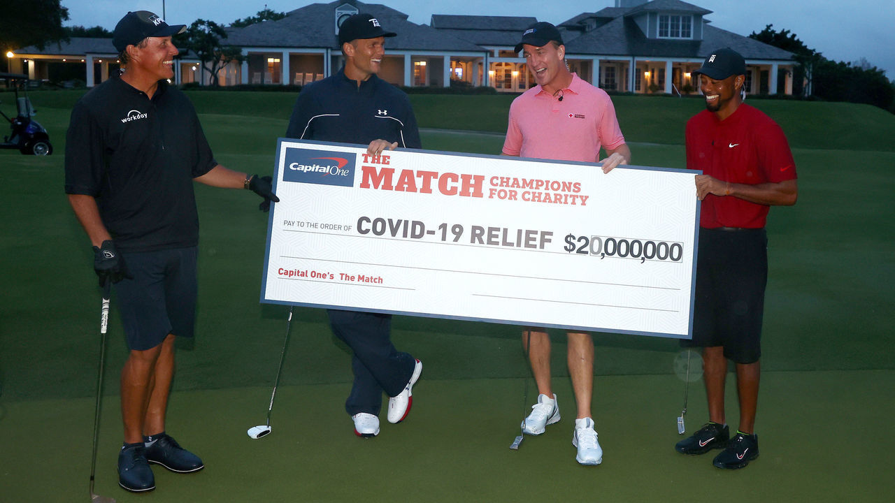 HOBE SOUND, FLORIDA - MAY 24: Tiger Woods and former NFL player Peyton Manning celebrate defeating Phil Mickelson and NFL player Tom Brady of the Tampa Bay Buccaneers on the 18th green during The Match: Champions For Charity at Medalist Golf Club on May 24, 2020 in Hobe Sound, Florida.