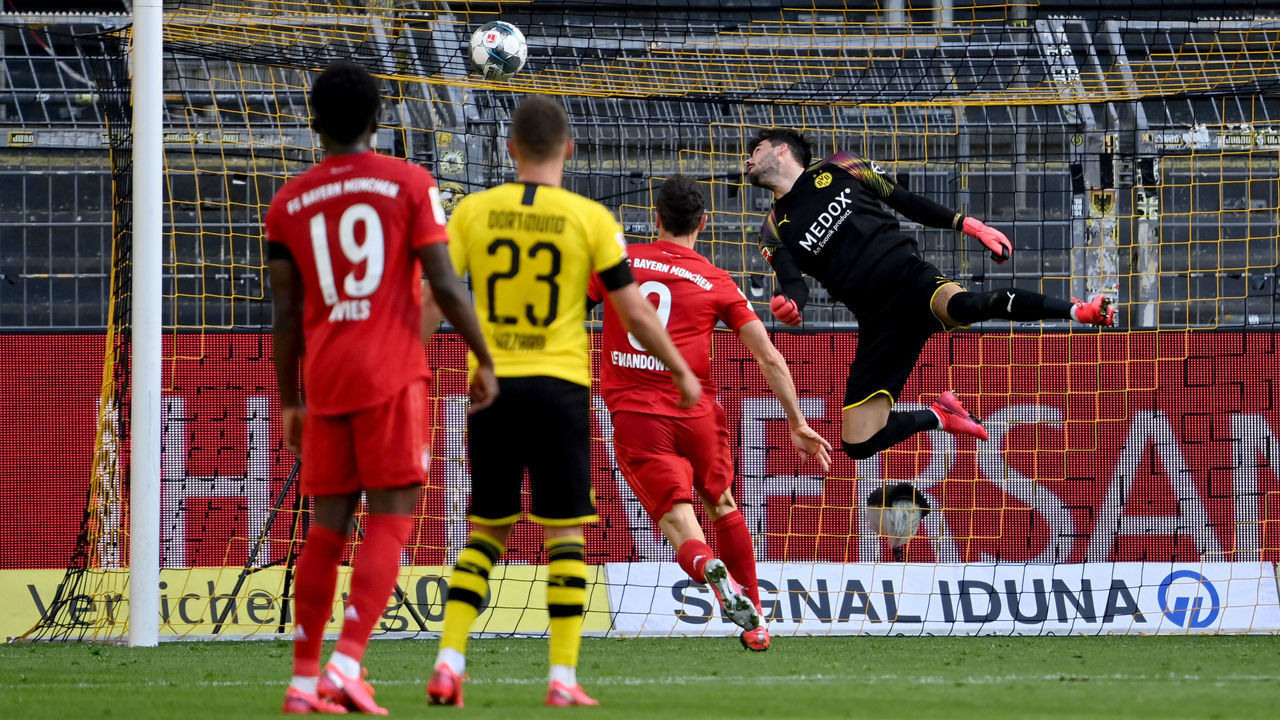 Dortmund's Swiss goalkeeper Roman Buerki (R) fails to keep out the opening goal scored by Bayern Munich's German midfielder Joshua Kimmich (not in picture) during the German first division Bundesliga football match BVB Borussia Dortmund v FC Bayern Munich on May 26, 2020 in Dortmund, western Germany.