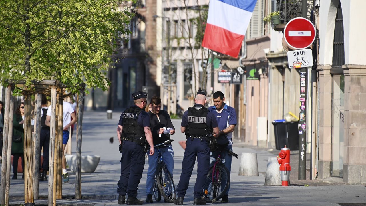 Police check passersby's self-certified note justifying their outing in Strasbourg, eastern France, on April 9, 2020, on the 24th day of a lockdown in France aimed at curbing the spread of the COVID-19 pandemic, caused by the novel coronavirus.
