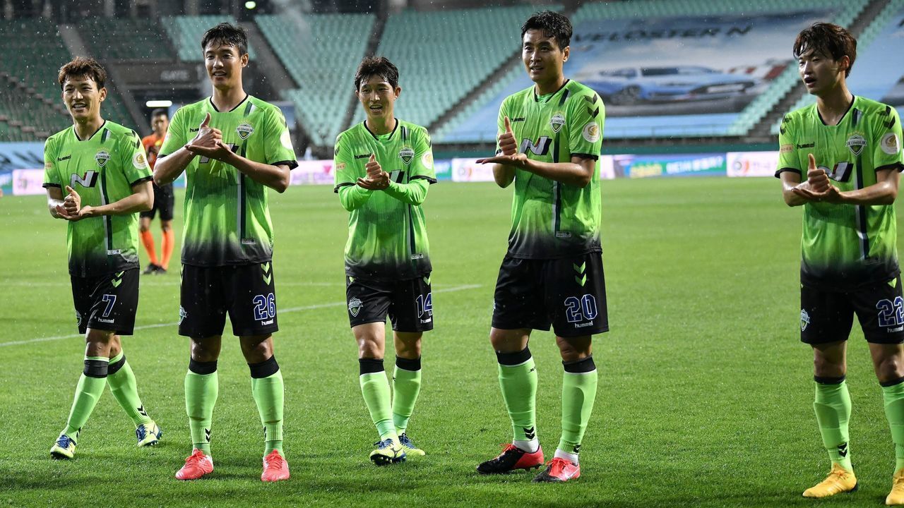 Jeonbuk Hyundai Motors' Lee Dong-gook (2nd R) and his teammates gesture a sign of 'respect' as he celebrates his goal against Suwon Samsung Bluewings during the opening game of South Korea's K-League football match at Jeonju World Cup Stadium in Jeonju on May 8, 2020. - The towering stands of the 42,477-capacity Jeonju World Cup Stadium stood empty on May 8 as South Korea opened football's post-coronavirus era without fans, but with an unprecedented international TV audience.