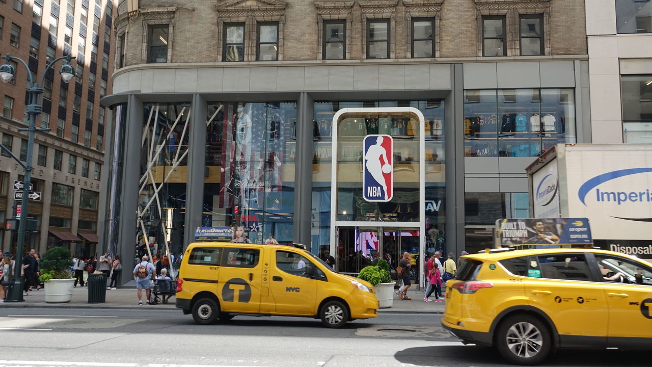 14 September 2019, US, New York: Yellow taxis drive past the NBA Store on Fifth Avenue in Manhattan. The shop carries merchandise of the team of the National Basketball Association (NBA) and Womens National Basketball Association (WNBA). Photo: Alexandra Schuler/dpa