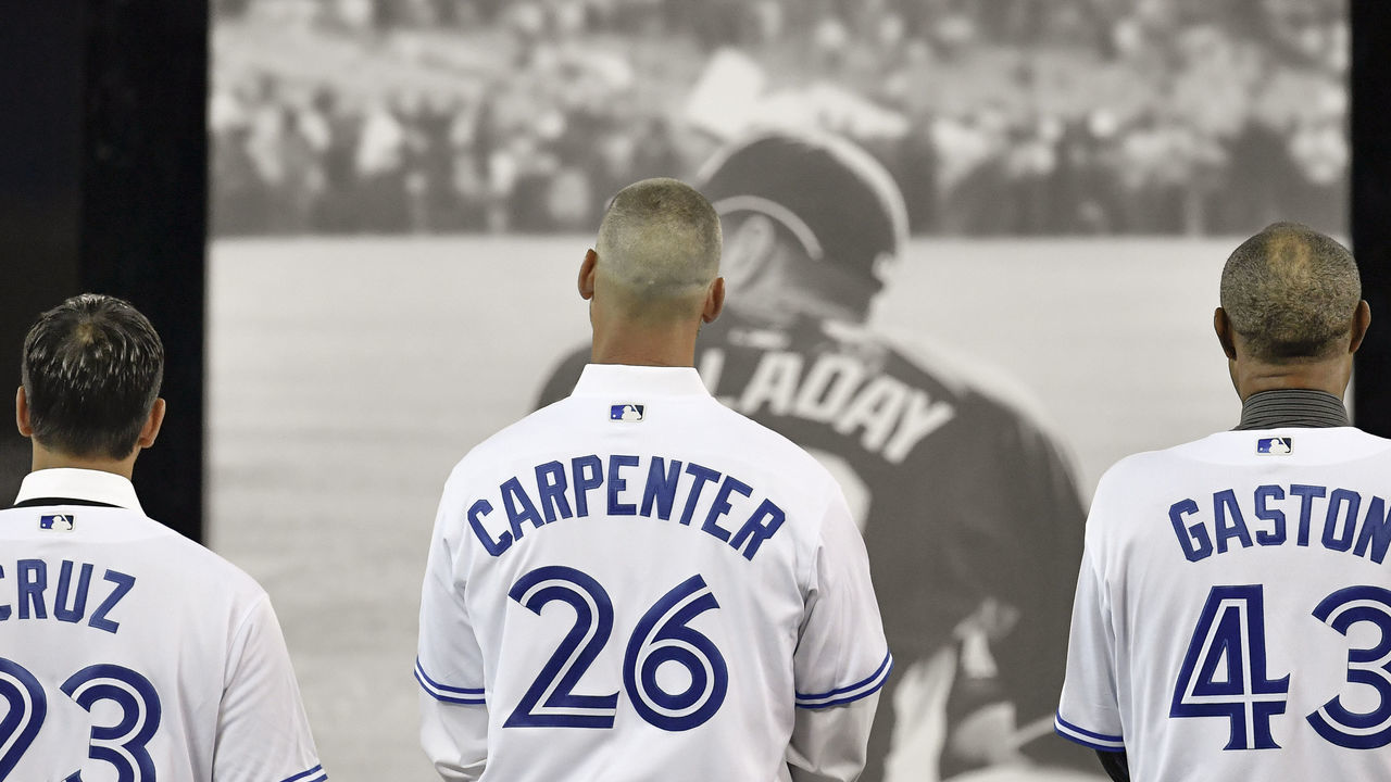 TORONTO, ON - MARCH 29: Blue Jays past players Jose Cruz Jr. (43) Chris Carpenter (26) and Manager Cito Gaston (43) during a ceremony honoring the late pitcher Roy Halladay. The team retired Halladay's No. 32 on opening day before the MLB season game between the New York Yankees and the Toronto Blue Jays at Rogers Centre in Toronto, ON., Canada March 29, 2018. Jays players will also wear a no. 32 patch on their jerseys throughout the season in tribute to Halladay. Halladay, nicknamed 'Doc' who spent 12 seasons as a pitcher with the Jays, died in November 2017 when his personal plane crashed into the Gulf of Mexico near Tampa. He was 40 years old. Halladay joins Robero Alomar (no. 12) as the only 2 players in Jays history to have their jersey numbers retired.