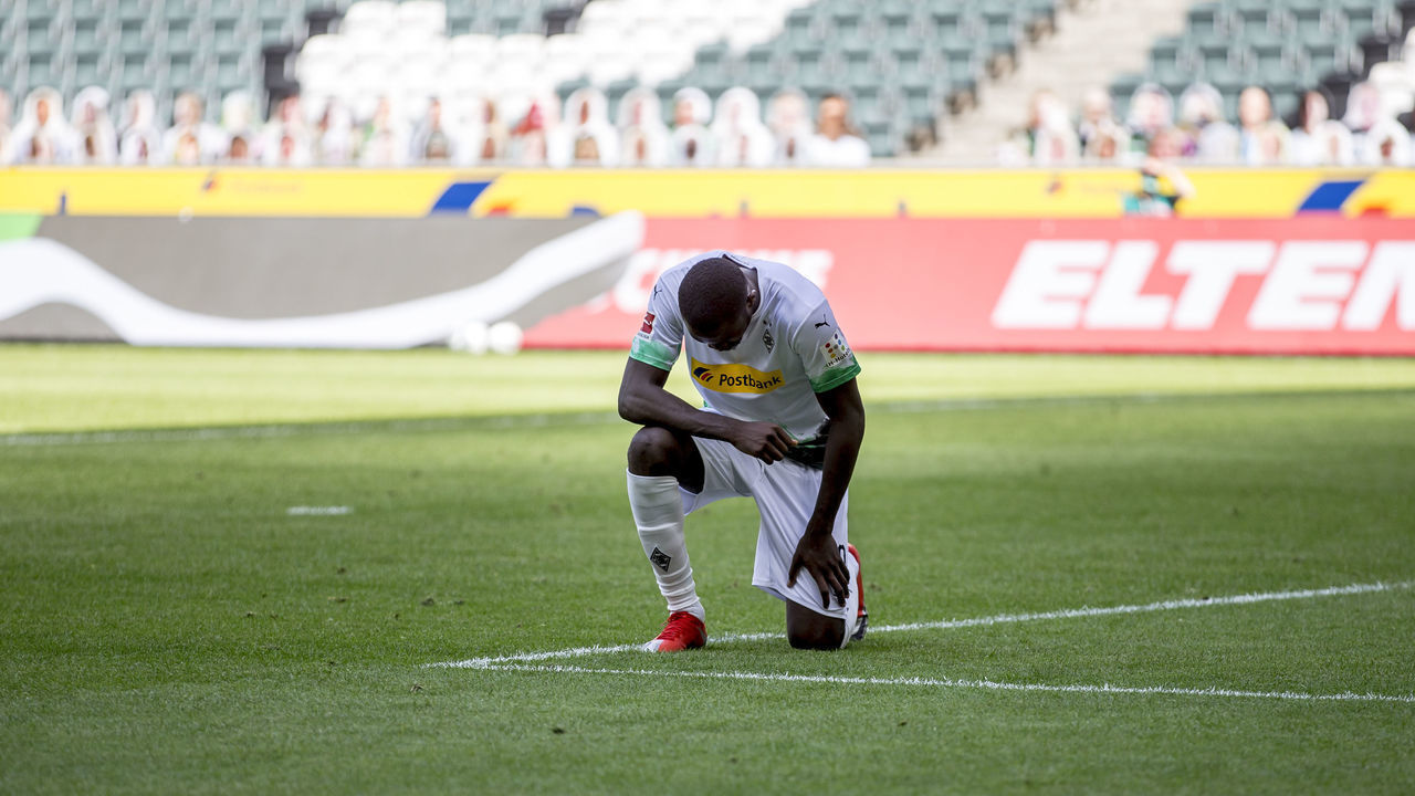 MOENCHENGLADBACH, GERMANY - MAY 31: Marcus Thuram of Borussia Moenchengladbach takes a knee after after he scores his Teams second goal during the Bundesliga match between Borussia Moenchengladbach and 1. FC Union Berlin at Borussia-Park on May 31, 2020 in Moenchengladbach, Germany.