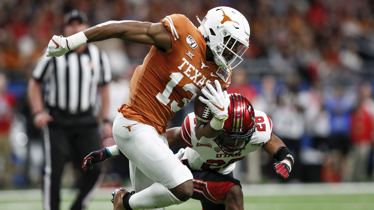 SAN ANTONIO, TX - DECEMBER 31: Brennan Eagles #13 of the Texas Longhorns runs after a reception defended by Terrell Burgess #26 of the Utah Utes in the first half during the Valero Alamo Bowl at the Alamodome on December 31, 2019 in San Antonio, Texas.
