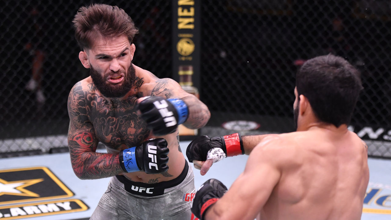 LAS VEGAS, NEVADA - JUNE 06: (L-R) Cody Garbrandt punches Raphael Assuncao of Brazil in their bantamweight bout during the UFC 250 event at UFC APEX on June 06, 2020 in Las Vegas, Nevada.