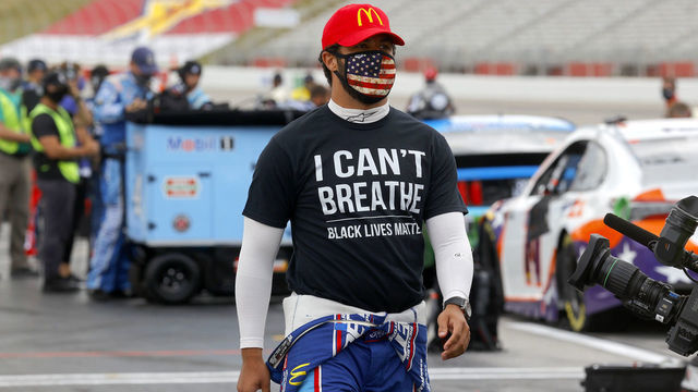 HAMPTON, GEORGIA - JUNE 07: Bubba Wallace, driver of the #43 McDonald's Chevrolet, wears a "I Can't Breath - Black Lives Matter" T-shirt under his fire suit in solidarity with protesters around the world taking to the streets after the death of George Floyd on May 25 while in the custody of Minneapolis, Minnesota police on the grid prior to the NASCAR Cup Series Folds of Honor QuikTrip 500 at Atlanta Motor Speedway on June 07, 2020 in Hampton, Georgia.