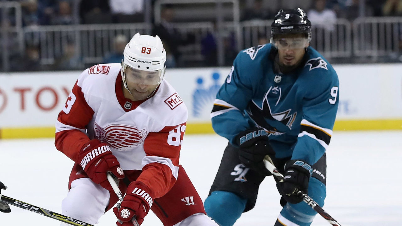 SAN JOSE, CA - MARCH 12: Trevor Daley #83 of the Detroit Red Wings skates between Chris Tierney #50 and Evander Kane #9 of the San Jose Sharks at SAP Center on March 12, 2018 in San Jose, California.