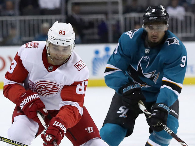 SAN JOSE, CA - MARCH 12: Trevor Daley #83 of the Detroit Red Wings skates between Chris Tierney #50 and Evander Kane #9 of the San Jose Sharks at SAP Center on March 12, 2018 in San Jose, California.