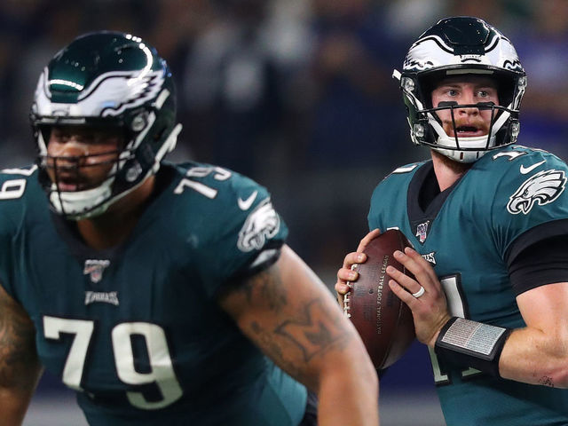 ARLINGTON TEXAS - OCTOBER 20 Carson Wentz 11 of the Philadelphia Eagles looks to pass as Brandon Brooks 79 blocks during the first half against the Dallas Cowboys in the game at ATT Stadium on October 20 2019 in Arlington Texas