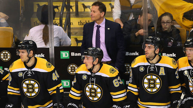 BOSTON - FEBRUARY 28: Bruins' coach Bruce Cassidy looks happy with what he sees, standing behind David Krejci, Brad Marchand and Patrice Bergeron with seconds left in the game and the Bruins ahead 4-1. The Boston Bruins host the Arizona Coyotes at TD Garden in Boston on Feb. 28, 2017.