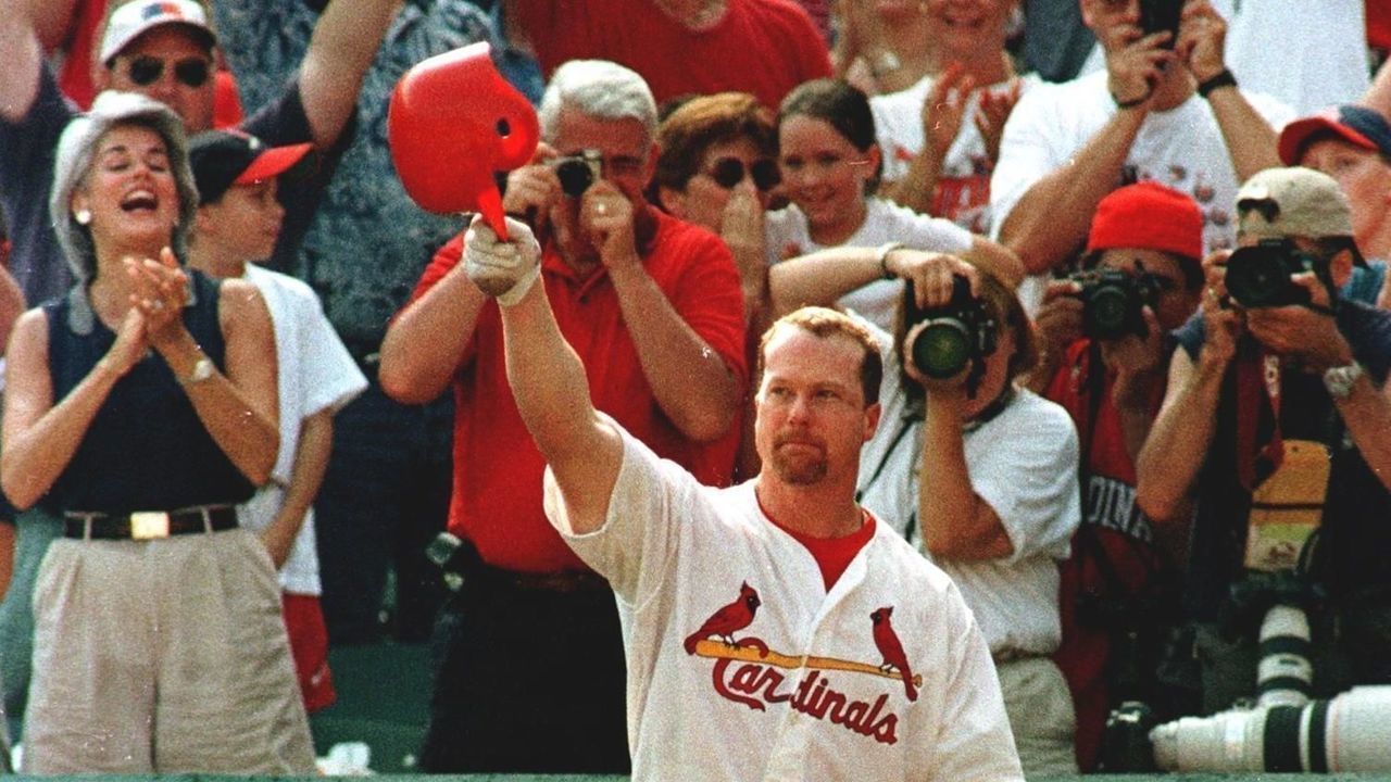 St. Louis Cardinal first baseman Mark McGwire salutes the fans at Busch Stadium after hitting his 70th home run of the season in the seventh inning against the Montreal Expos giving him a giving the record for home runs on the year. McGwire hit his 69th earlier in the third inning. The Cardinals beat the Expos 6-3. AFP PHOTO/PHOTO Peter NEWCOMB