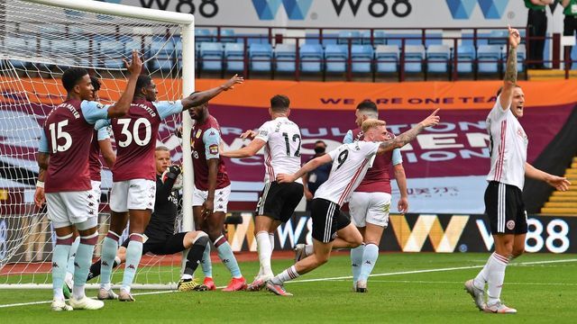 Aston Villa's Norwegian goalkeeper Orjan Nyland (3rd L) falls back into the goal holding the ball as the Sheffield United players celebrate a goal which wasn't awarded during the English Premier League football match between Aston Villa and Sheffield United at Villa Park in Birmingham, central England on June 17, 2020. - The Premier League makes its eagerly anticipated return today after 100 days in lockdown but behind closed doors due to coronavirus restrictions.
