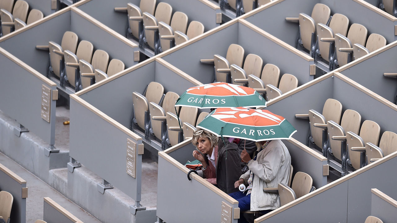 PARIS, FRANCE - JUNE 07: Fans are waiting in the as the covers are pulled over Court Philippe Chatrier due to a rain delay on Day thirteen of the 2019 French Open at Roland Garros on June 07, 2019 in Paris, France.