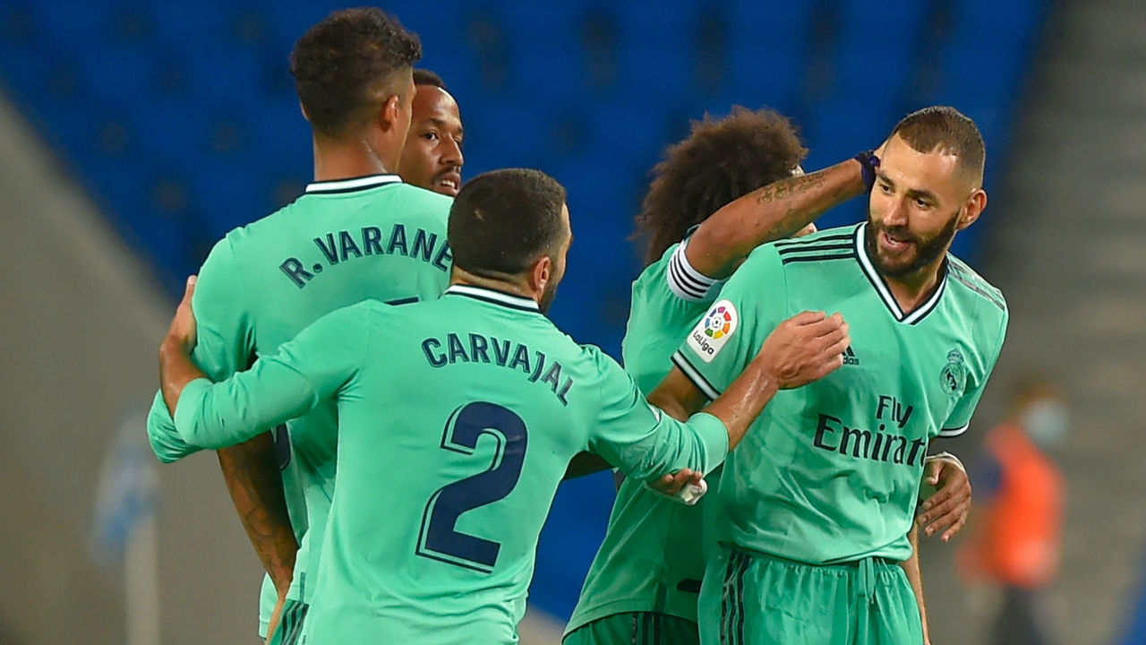 Real Madrid's French forward Karim Benzema (R) celebrates with teammates after scoring during the Spanish League football match between Real Sociedad and Real Madrid at the Reale Arena-Anoeta Stadium in San Sebastian on June 21, 2020.
