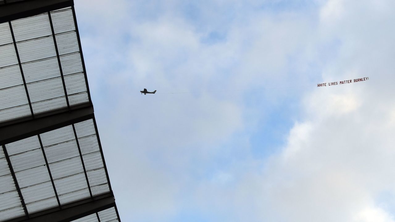 TOPSHOT - A plane towing a banner reading 'White Lives Matter Burnley' is seen in the sky above the stadium during the English Premier League football match between Manchester City and Burnley at the Etihad Stadium in Manchester, north west England, on June 22, 2020.