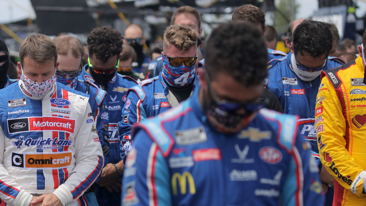 TALLADEGA, ALABAMA - JUNE 22: NASCAR drivers stand in solidarity with Bubba Wallace, driver of the #43 Victory Junction Chevrolet, during the national anthem prior to the NASCAR Cup Series GEICO 500 at Talladega Superspeedway on June 22, 2020 in Talladega, Alabama. A noose was found in the garage stall of NASCAR driver Bubba Wallace at Talladega Superspeedway a week after the organization banned the Confederate flag at its facilities.