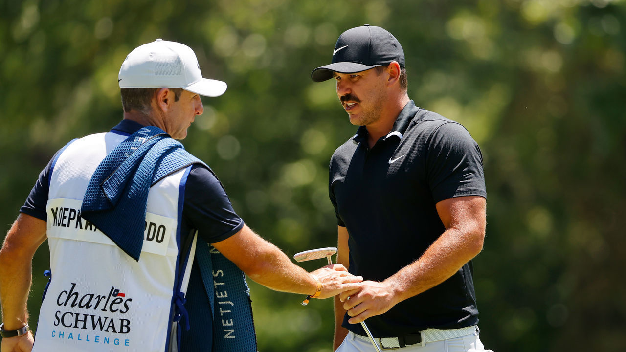 FORT WORTH, TEXAS - JUNE 13: Brooks Koepka of the United States hands his putter to his caddie Ricky Elliott on the eighth green during the third round of the Charles Schwab Challenge on June 13, 2020 at Colonial Country Club in Fort Worth, Texas.