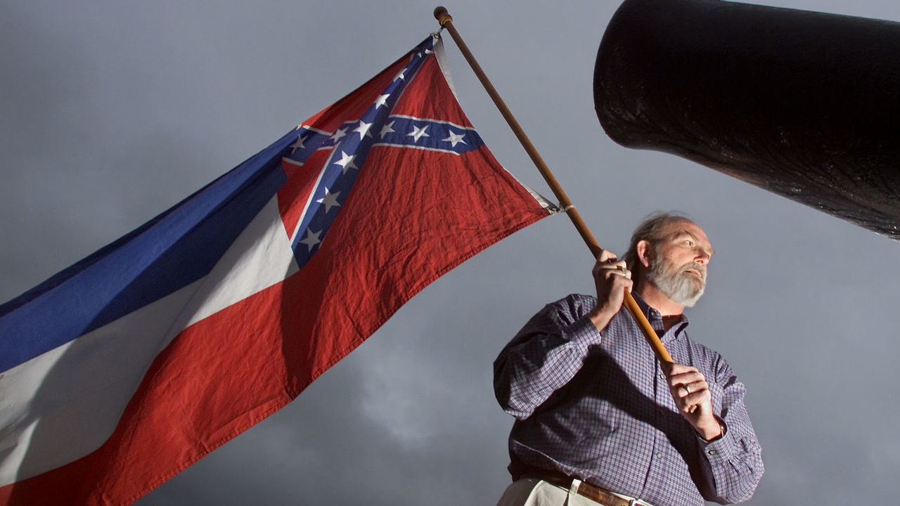 USA_Post911_BW03--12/12/01--Harry Sharp, the 5th cousin of Confederate General Robert E. Lee, proudly holds the Mississippi State flag in the centre of Vicksberg Mississippi, beside a civil war cannon overlooking the Mississippi River, December 12. A fierce battle was fought in Vicksberg during the Civil War. The flag bears the original Confederate cross, with the blue, white, and red bars. (BERNARD WEIL/TORONTO STAR) DIGITAL IMAGE