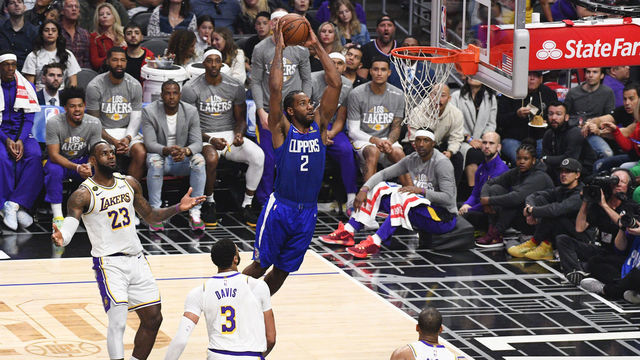 LOS ANGELES, CA - MARCH 08: Los Angeles Clippers Forward Kawhi Leonard (2) goes up for a dunk as Los Angeles Lakers Forward LeBron James (23) looks on during a NBA game between the Los Angeles Lakers and the Los Angeles Clippers on March 8, 2020 at STAPLES Center in Los Angeles, CA.