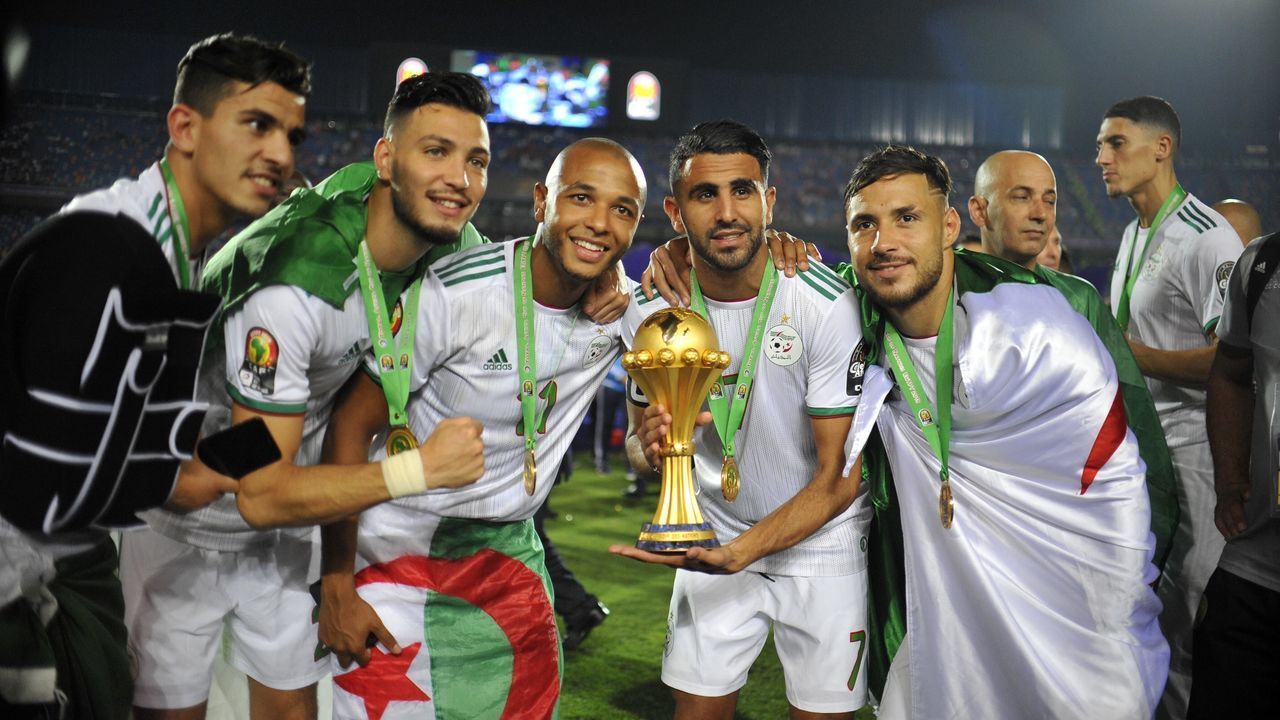 Algeria's Riyad Mahrez (2-R) and Yacine Brahimi (3-L) celebrate the trophy with their teammate after Algeria defeated Senegal in the 2019 Africa Cup of Nations final soccer match at the Cairo International Stadium.