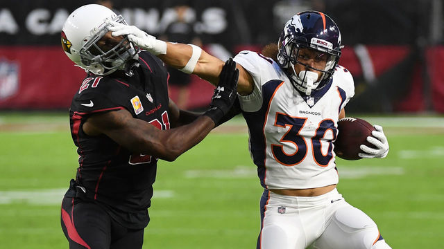 GLENDALE, AZ - OCTOBER 18: Phillip Lindsay #30 of the Denver Broncos runs with the ball while straight arming Patrick Peterson #21 of the Arizona Cardinals at State Farm Stadium on October 18, 2018 in Glendale, Arizona.