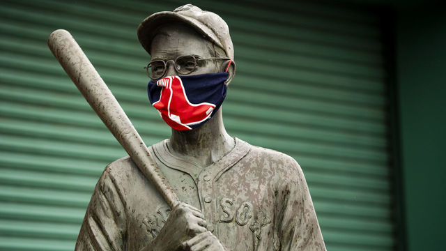 BOSTON, MA - APRIL 9: The "Teammates" statues of former Boston Red Sox players Ted Williams, Bobby Doerr, Johnny Pesky and Dom DiMaggio wear makeshift masks made of Red Sox merchandise as the Major League Baseball season is postponed due the coronavirus pandemic on April 9, 2020 at Fenway Park in Boston, Massachusetts.
