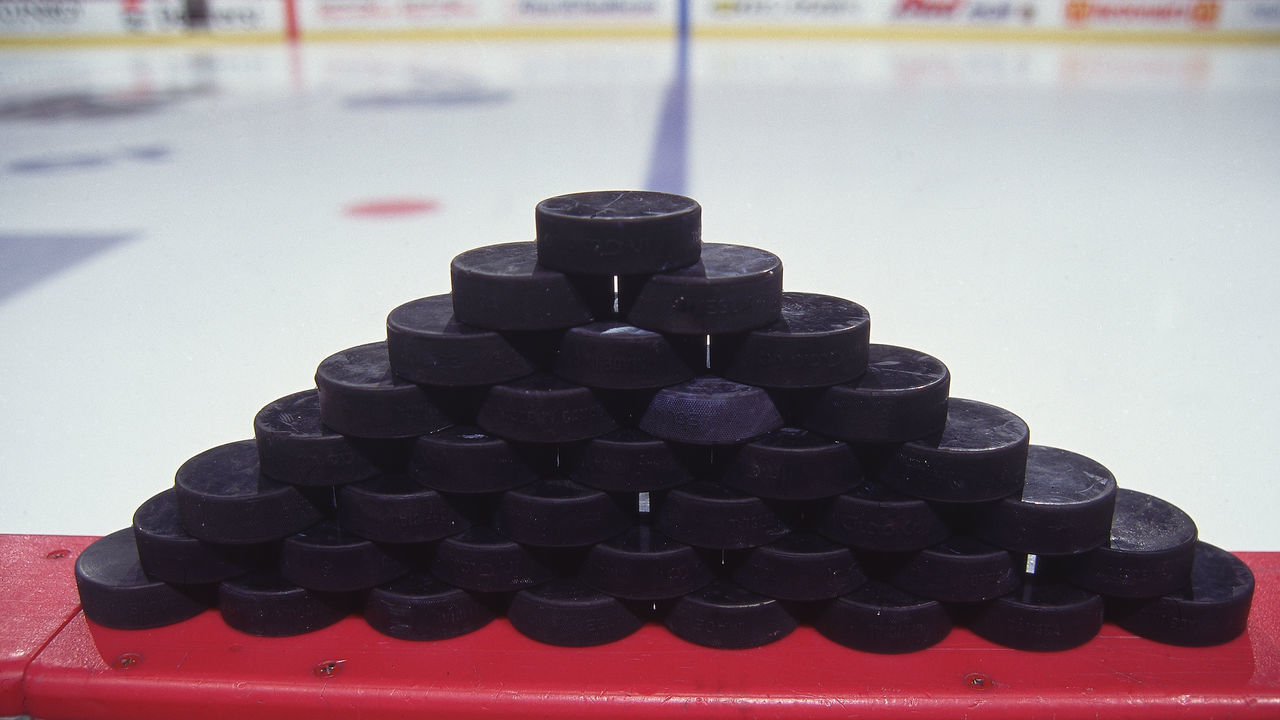 Close-up view of a stack of 36 hockey pucks on the boards, April 1998.