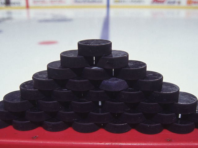 Close-up view of a stack of 36 hockey pucks on the boards, April 1998.