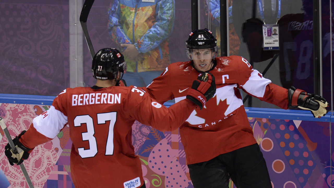 Canada's Sidney Crosby (R) celebrates with Canada's Patrice Bergeron during the Men's ice hockey final Sweden vs Canada at the Bolshoy Ice Dome during the Sochi Winter Olympics on February 23, 2014. AFP PHOTO / ALEXANDER NEMENOV