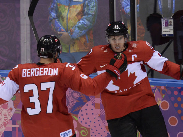 Canada's Sidney Crosby (R) celebrates with Canada's Patrice Bergeron during the Men's ice hockey final Sweden vs Canada at the Bolshoy Ice Dome during the Sochi Winter Olympics on February 23, 2014. AFP PHOTO / ALEXANDER NEMENOV