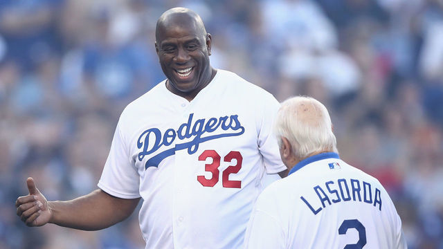 LOS ANGELES, CA - OCTOBER 26: Former Los Angeles Lakers player Magic Johnson and former Los Angeles Dodgers player Tomy Lasorda embrace prior to Game Three of the 2018 World Series between the Los Angeles Dodgers and the Boston Red Sox at Dodger Stadium on October 26, 2018 in Los Angeles, California.