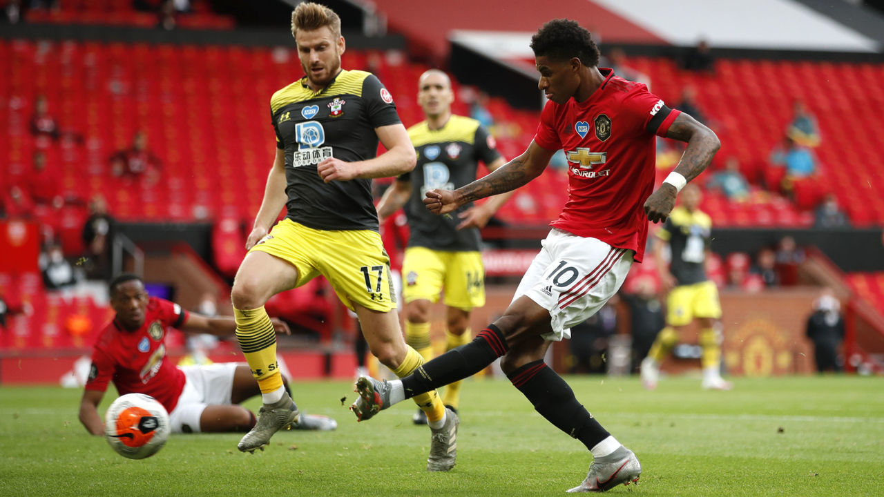 MANCHESTER, ENGLAND - JULY 13: Marcus Rashford of Manchester United scores his team's first goal during the Premier League match between Manchester United and Southampton FC at Old Trafford on July 13, 2020 in Manchester, England. Football Stadiums around Europe remain empty due to the Coronavirus Pandemic as Government social distancing laws prohibit fans inside venues resulting in all fixtures being played behind closed doors.