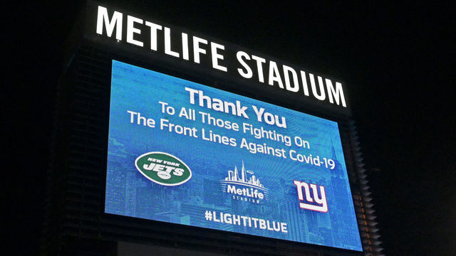 EAST RUTHERFORD, NJ - APRIL 09: Sings outside of Metlife Stadium honor essential workers on April 09, 2020 in East Rutherford, New Jersey. Landmarks and buildings across the nation are displaying blue lights to show support for health care workers and first responders on the front lines of the COVID-19 pandemic.