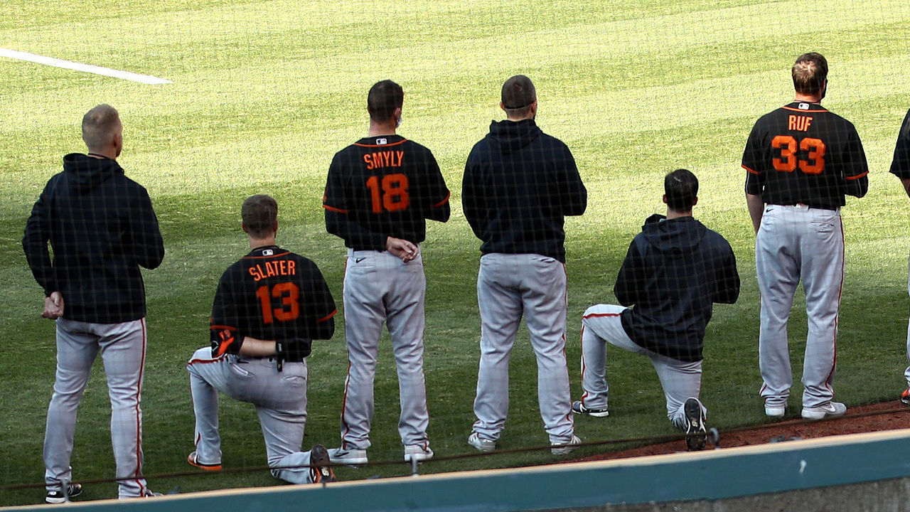 OAKLAND, CALIFORNIA - JULY 20: Austin Slater #13 and Jaylin Davis #49 of the San Francisco Giants kneel during the National Anthem before their exhibition game against the Oakland Athletics at Oakland-Alameda County Coliseum on July 20, 2020 in Oakland, California.