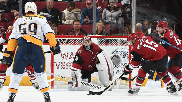 GLENDALE, AZ - NOVEMBER 15: Darcy Kuemper #35 of the Arizona Coyotes gets ready to make a save as teammate Brad Richardson #15 clears the puck against the Nashville Predators at Gila River Arena on November 15, 2018 in Glendale, Arizona.