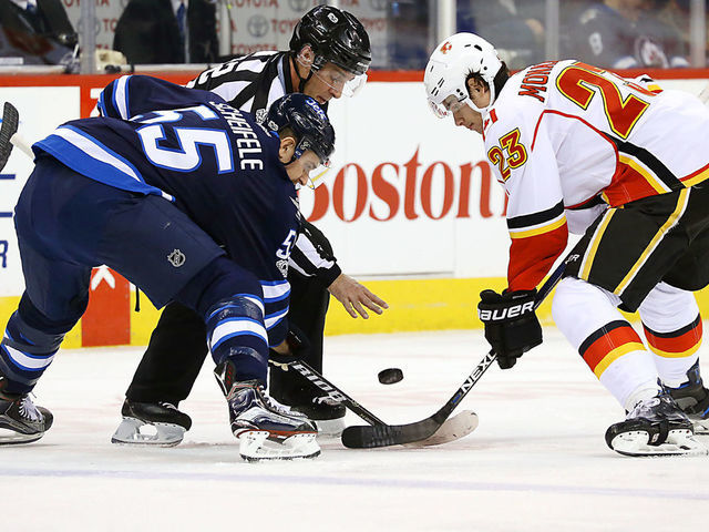 WINNIPEG, MB - MARCH 11: Mark Scheifele #55 of the Winnipeg Jets takes a first period face-off against Sean Monahan #23 of the Calgary Flames at the MTS Centre on March 11, 2017 in Winnipeg, Manitoba, Canada.