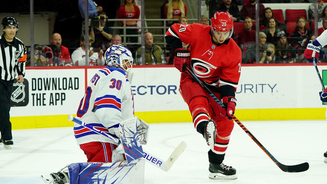 RALEIGH, NC - NOVEMBER 7: Sebastian Aho #20 of the Carolina Hurricanes creates traffic in front of Henrik Lundqvist #30 of the New York Rangers who goes down in the crease to protect the net during an NHL game on November 7, 2019 at PNC Arena in Raleigh, North Carolina.