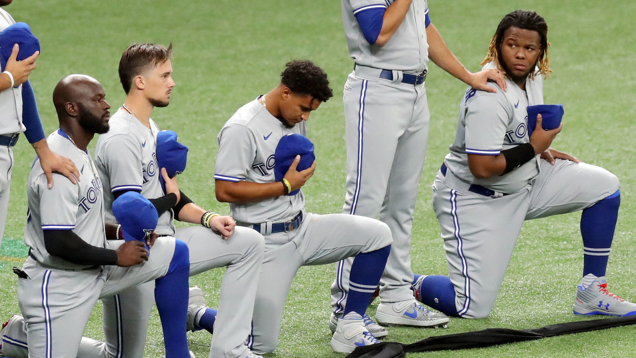 ST. PETERSBURG, FL - JULY 24: Vladimir Guerrero Jr. #27, Santiago Espinal #5 Cavan Biggio #8 and Al Alford #30 of the Toronto Blue Jays kneel during the national anthem prior to the game between the Toronto Blue Jays and the Tampa Bay Rays at Tropicana Field on Friday, July 24, 2020 in St. Petersburg, Florida.