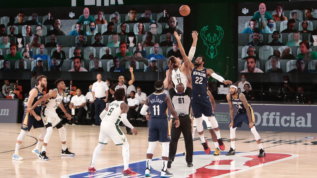 ORLANDO, FL - JULY 27: Brook Lopez #11 of the Milwaukee Bucks jumps the opening tip against Derrick Favors #22 of the New Orleans Pelicans as part of the NBA Restart 2020 on July 27, 2020 at The Arena at ESPN Wide World of Sports Complex in Orlando, Florida. NOTE TO USER: User expressly acknowledges and agrees that, by downloading and/or using this photograph, user is consenting to the terms and conditions of the Getty Images License Agreement. Mandatory Copyright Notice: Copyright 2020 NBAE