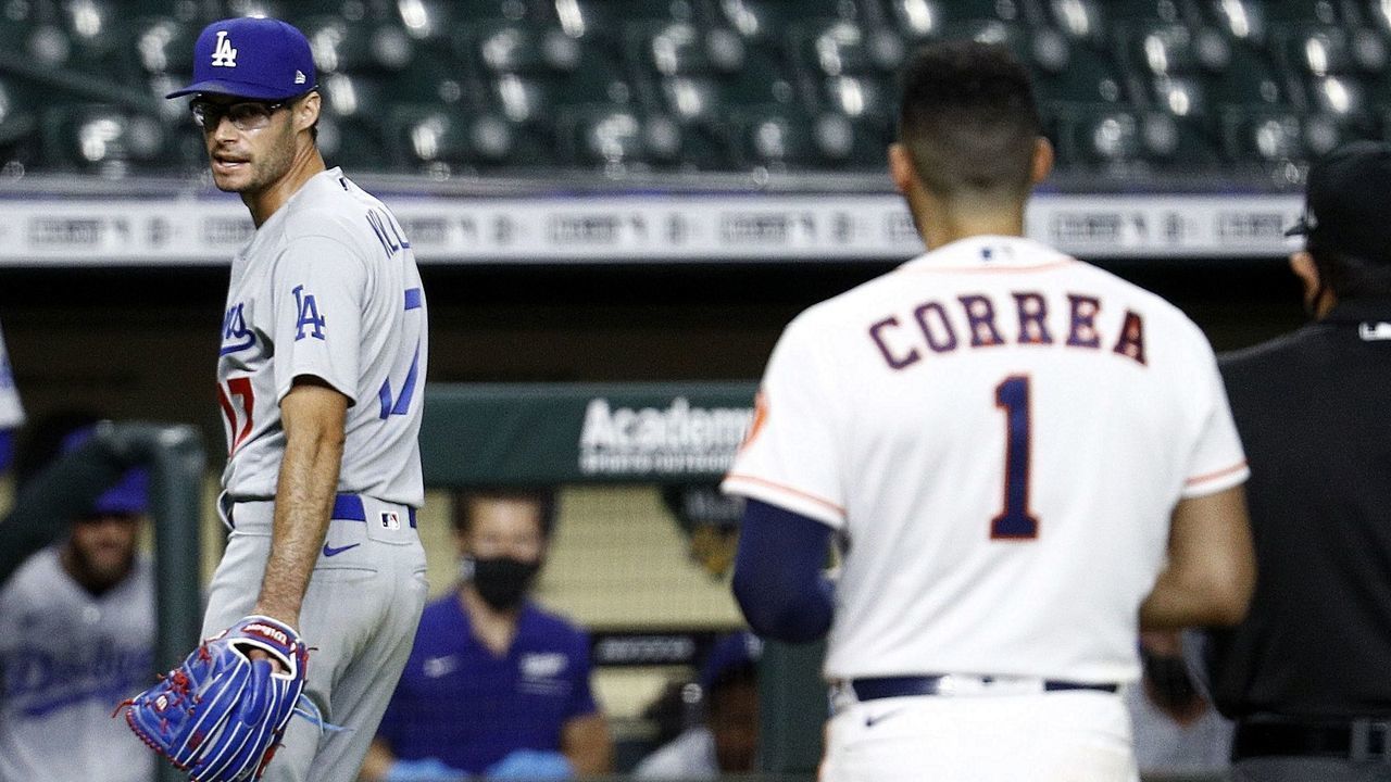 HOUSTON, TEXAS - JULY 28: Joe Kelly #17 of the Los Angeles Dodgers has a word with Carlos Correa #1 of the Houston Astros as he walks off the mound after a series of high inside pitches in the sixth inning at Minute Maid Park on July 28, 2020 in Houston, Texas. Both benches emptied.