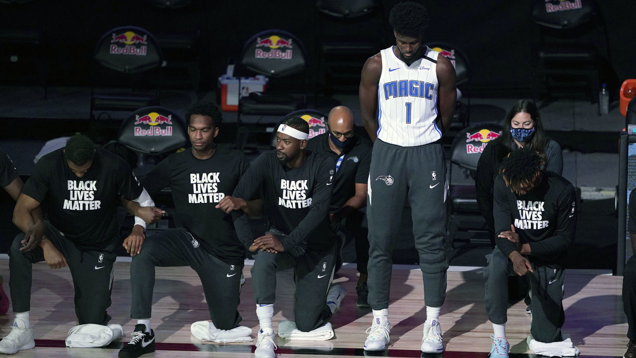 LAKE BUENA VISTA, FL - JULY 31: Jonathan Isaac #1 of the Orlando Magic stands as others kneel before the start of a game between the Brooklyn Nets and the Orlando Magic on July 31, 2020 at The HP Field House at ESPN Wide World Of Sports Complex in Lake Buena Vista, Florida. NOTE TO USER: User expressly acknowledges and agrees that, by downloading and/or using this Photograph, user is consenting to the terms and conditions of the Getty Images License Agreement.