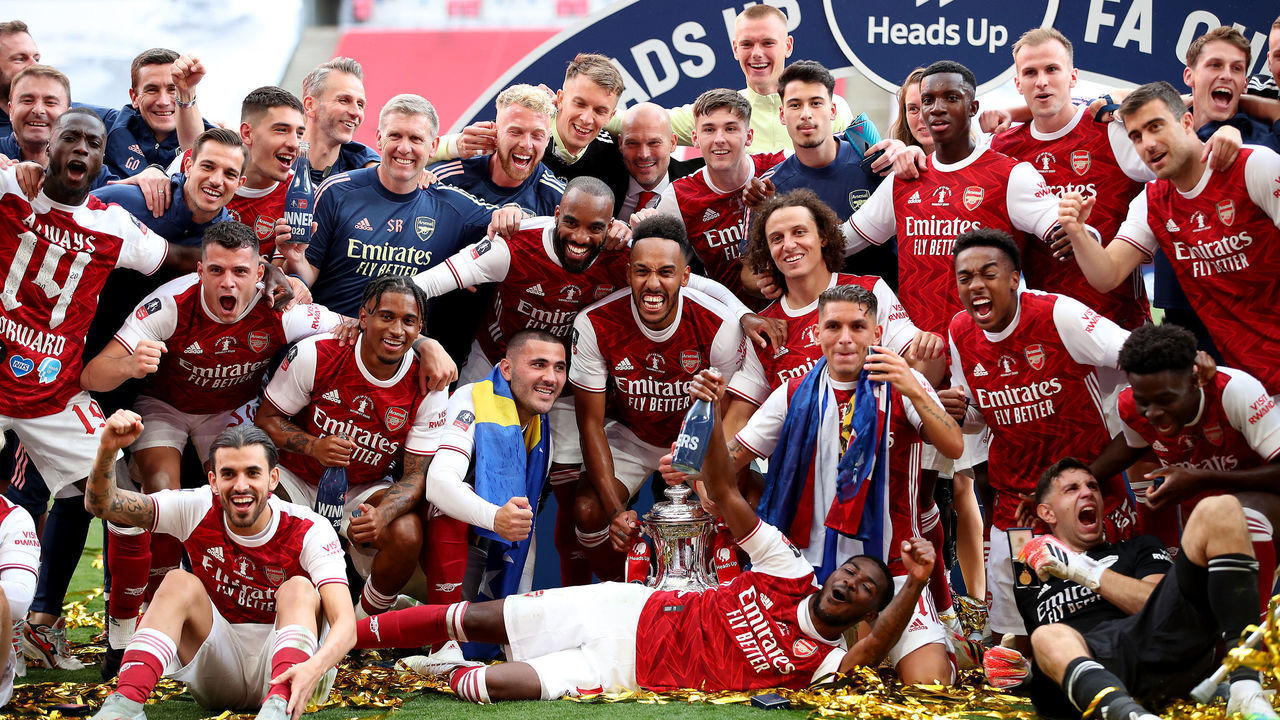 LONDON, ENGLAND - AUGUST 01: Arsenal players celebrate with the FA Cup Trophy after their teams victory in the Heads Up FA Cup Final match between Arsenal and Chelsea at Wembley Stadium on August 01, 2020 in London, England. Football Stadiums around Europe remain empty due to the Coronavirus Pandemic as Government social distancing laws prohibit fans inside venues resulting in all fixtures being played behind closed doors.