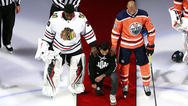 EDMONTON, ALBERTA - AUGUST 01: Malcolm Subban #30 of the Chicago Blackhawks and Darnell Nurse #25 of the Edmonton Oilers place their hands on Mathew Dumba of the Minnesota Wild during the national anthem of the United States before the Game One of the Eastern Conference Qualification Round prior to the 2020 NHL Stanley Cup Playoffs at Rogers Place on August 01, 2020 in Edmonton, Alberta.Dumba spoke before the game about the NHL's support of Black Lives Matter and ending racism.